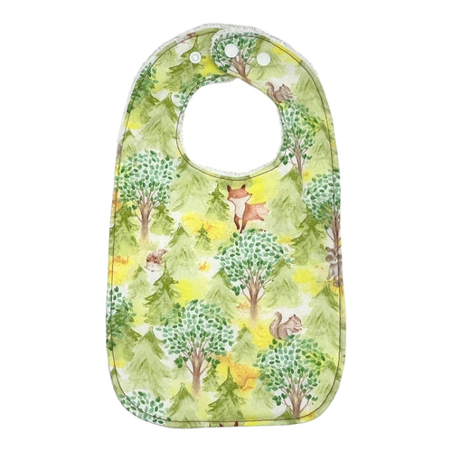 Baby Everyday bib by Mimi's Little Loveys. Features cute foxes, raccoons, squirrels in a forest scene. Shades of browns, oranges, grays, and greens, on a yellow background. Backing is white terry cloth.