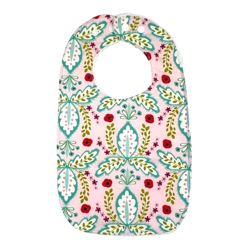 Baby bib by Mimi’s Little Loveys. A paisley style design with red roses on a pink background.