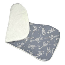 Load image into Gallery viewer, Burpcloth Set by Mimi's Little Loveys. Fun, white, dinosaur skeletons on a gray background. Backing is white terry cloth.