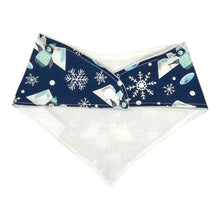 Load image into Gallery viewer, Baby bandana-style bib with penguins fishing, icebergs, and snowflakes, on a blue background. Rear view with white flannel backing and snap fastener.