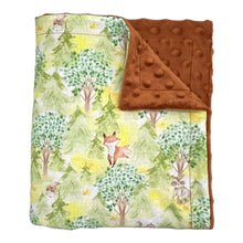 Load image into Gallery viewer, Baby blanket by Mimi’s Little Loveys. Features cute foxes, raccoons, squirrels in a forest scene. Shades of browns, oranges, grays, and greens, on a yellow background. Backing is a brown minky.