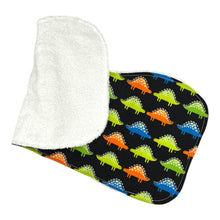 Load image into Gallery viewer, Folded burpcloth with colorful dinosaur pattern on a black background.