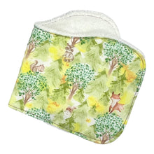 Load image into Gallery viewer, Burpcloth set by Mimi's Little Loveys. Features cute foxes, raccoons, squirrels in a forest scene. Shades of browns, oranges, grays, and greens, on a yellow background. Backing is white terry cloth.