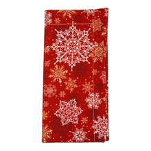 Load image into Gallery viewer, A folded red dinner napkin with a white, gold, and red snowflake pattern.