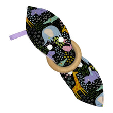 Load image into Gallery viewer, Baby Crinkle Teether by Mimi's Little Loveys. Fun and vibrant design, featuring crocodiles, elephants, flamingos, giraffes, hippos, tortoises, plants, and flowers, on a black background. Backing is dimple dot minky. Wooden teething ring.