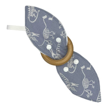 Load image into Gallery viewer, Baby Crinkle Teether by Mimi's Little Loveys. Fun, white, dinosaur skeletons on a gray background, and a wooden teething ring.