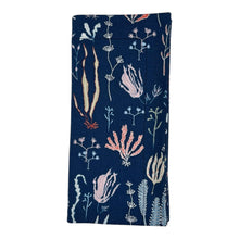 Load image into Gallery viewer, Folded navy blue napkin with coral and sea life design.