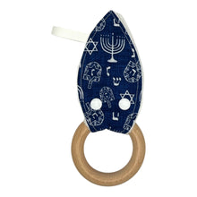 Load image into Gallery viewer, Navy blue baby teether with white Hanukkah menorahs, dreidels, and Stars of David.