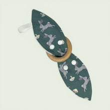 Load image into Gallery viewer, Teething ring with wooden ring and green fabric cover featuring rabbit designs