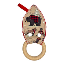 Load image into Gallery viewer, A teether with a fabric winter plaid pattern featuring bears, beavers, deer, and foxes in a snowy setting. Wooden teething ring.