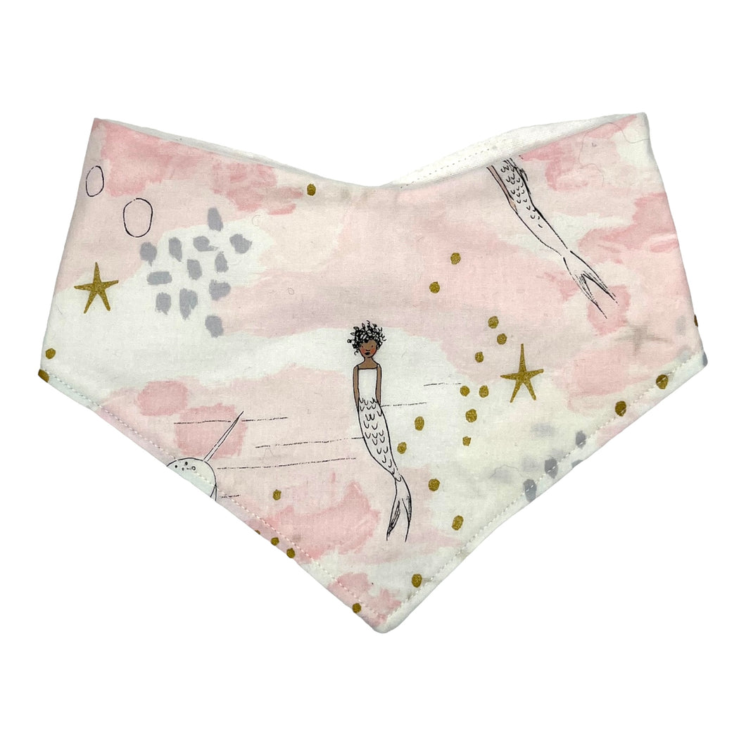 Baby bandana bib by Mimi's Little Loveys. Whimsical mermaids & narwhals on a light pink background with metallic gold accents.