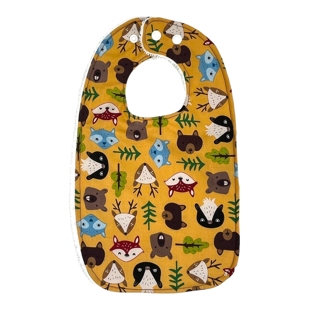 Baby bib Everyday Bib by Mimi's Little Loveys. Fun and vibrant design, featuring group of Maine friends - bear, beaver, deer, fox, raccoon, and skunk - on a mustard yellow background. Backing is soft, white, terry cloth.