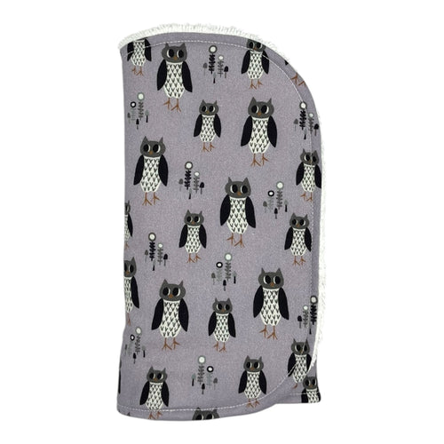 Burpcloth with owl pattern on a light purple background.