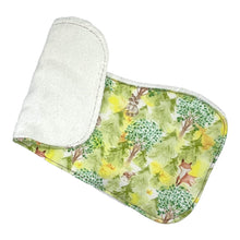 Load image into Gallery viewer, Burpcloth set by Mimi's Little Loveys. Features cute foxes, raccoons, squirrels in a forest scene. Shades of browns, oranges, grays, and greens, on a yellow background. Backing is white terry cloth.
