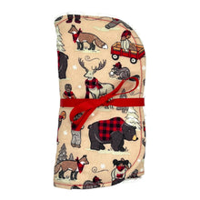 Load image into Gallery viewer, A burp cloth set with a winter plaid pattern featuring bears, beavers, deer, and foxes in a snowy setting, with a red ribbon tie at the center.
