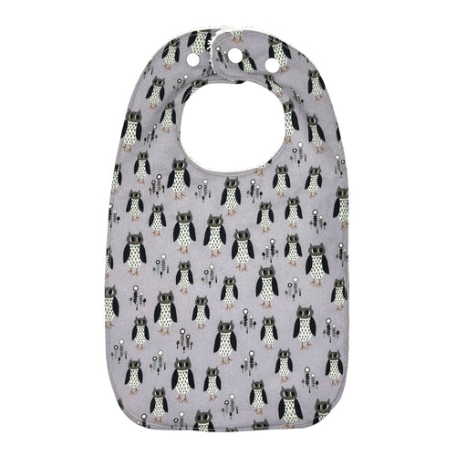 Baby bib with owl pattern on a light purple background.
