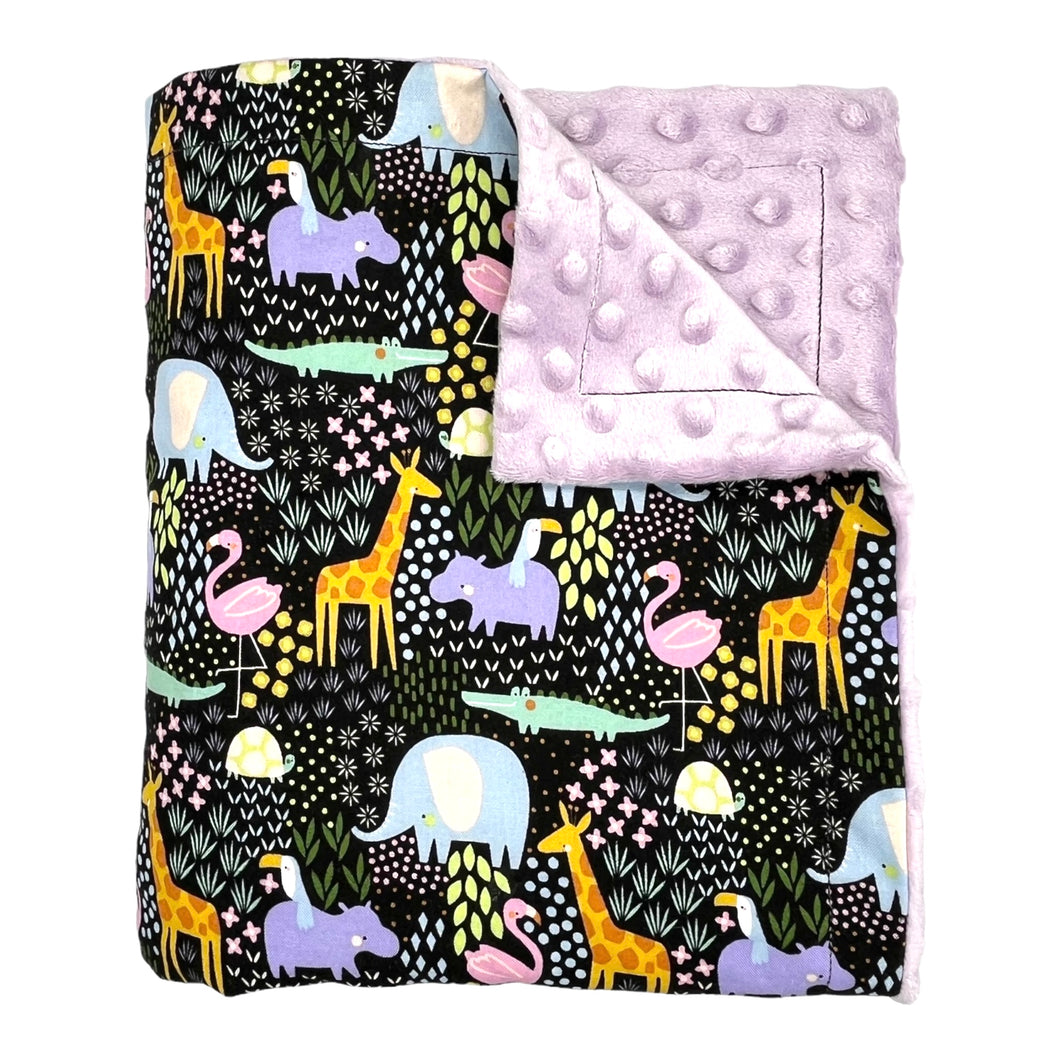 Baby Blanket by Mimi's Little Loveys. Fun and vibrant design, featuring crocodiles, elephants, flamingos, giraffes, hippos, tortoises, plants, and flowers, on a black background. Backing is dimple dot minky.