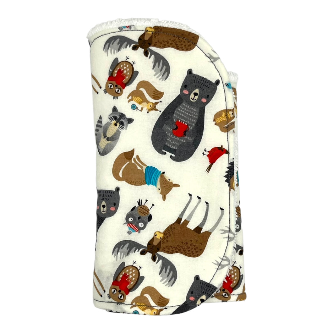 Burpcloth set by Mimi's Little Loveys. Front features a collection of Maine critters: bears, cardinals, deer, moose, owls, porcupines, raccoons, squirrels, all on a white background. Backing is soft, white, terry cloth.