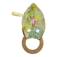 Load image into Gallery viewer, Baby Crinkle Teether by Mimi's Little Loveys. Features cute foxes, raccoons, squirrels in a forest scene. Shades of browns, oranges, grays, and greens, on a yellow background, and a wooden teething ring.
