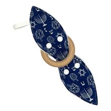 Load image into Gallery viewer, Navy blue baby teether with white Hanukkah menorahs, dreidels, and Stars of David.
