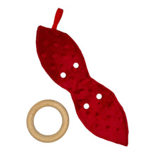 Load image into Gallery viewer, A teether with a fabric winter plaid pattern featuring bears, beavers, deer, and foxes in a snowy setting. Red minky backing. Wooden teething ring.
